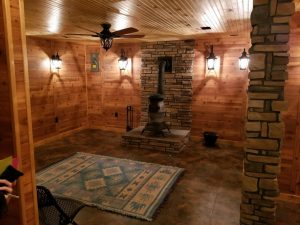 authentic wood walls and ceiling with stone pillar and wood stove heating