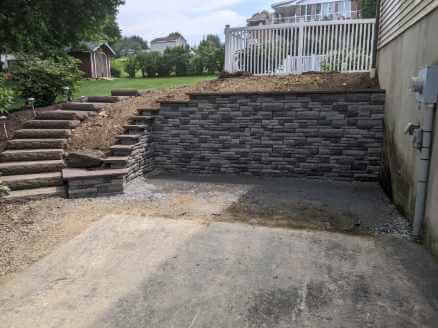 outdoor staircase curving around a retaining wall holding up a dirt garden