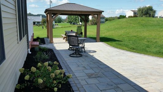 stone patio along side of house with pavilion
