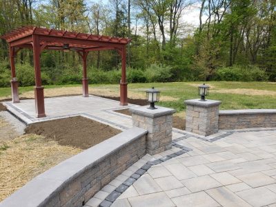 completed patio with red wood shade roof and pathway lit by lanturns