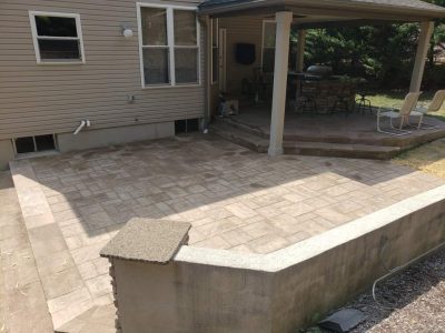 smooth stone wall partially wrapping around a stone patio