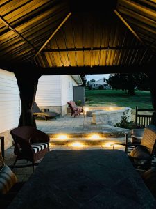 covered outdoor seating area with lit up steps and walkway