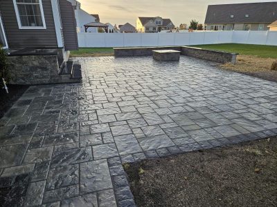 closeup of patio pattern when completed stone patio with alternating stone shapes and a square brick border