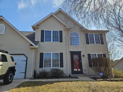 yellow two story home before exterior remodel of the facade