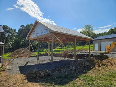 Pergola structure taking shape during construction of a custom backyard patio and outdoor living area